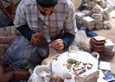 Man chipping tiles at a ceramics factory in Fes in Morocco