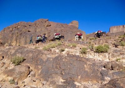 Hiking over volcanic rock on a private guide hike in Jebel Saghro mountain range with Experience Morocco