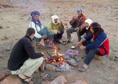 Sitting around the campfire on a guided hike in Jebel Saghro mountain range with Experience Morocco